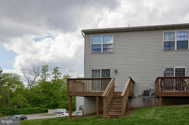 a view of a house with wooden deck and furniture