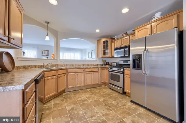 a large kitchen with stainless steel appliances granite countertop a stove a sink and a refrigerator