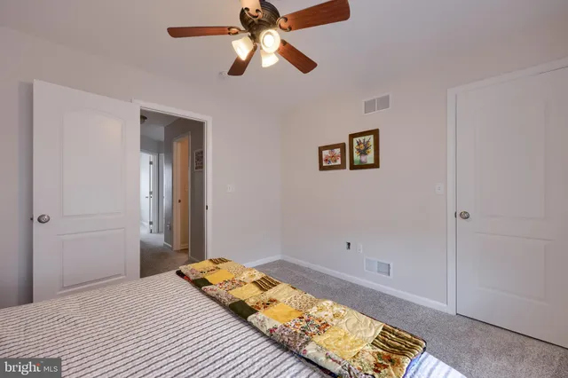 a bedroom with a bed and a chandelier fan