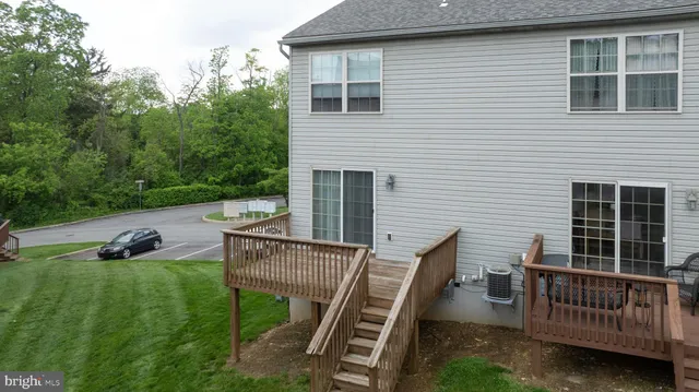 a view of a deck with couches chairs and wooden fence
