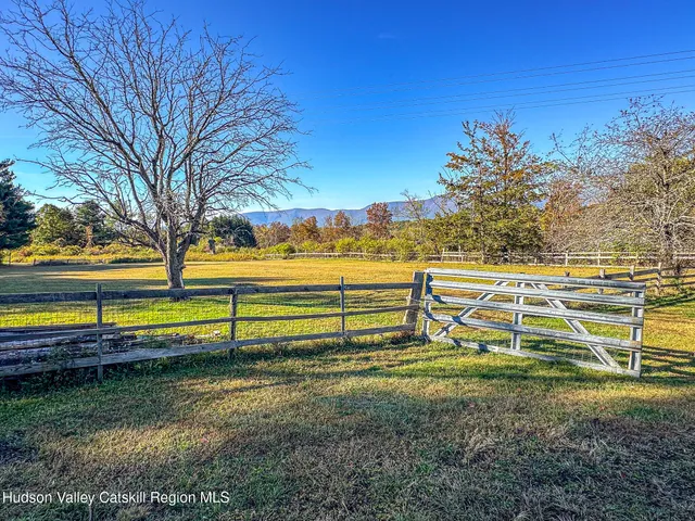a view of a yard with swimming pool and wooden fence