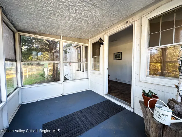 a view of a porch with furniture and floor to ceiling window