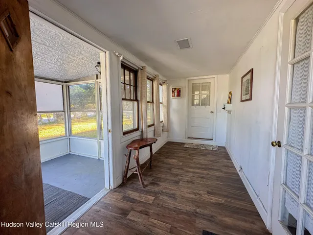 a view of a hallway with wooden floor and a livingroom