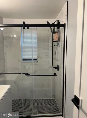 a bathroom with a shower and a glass door