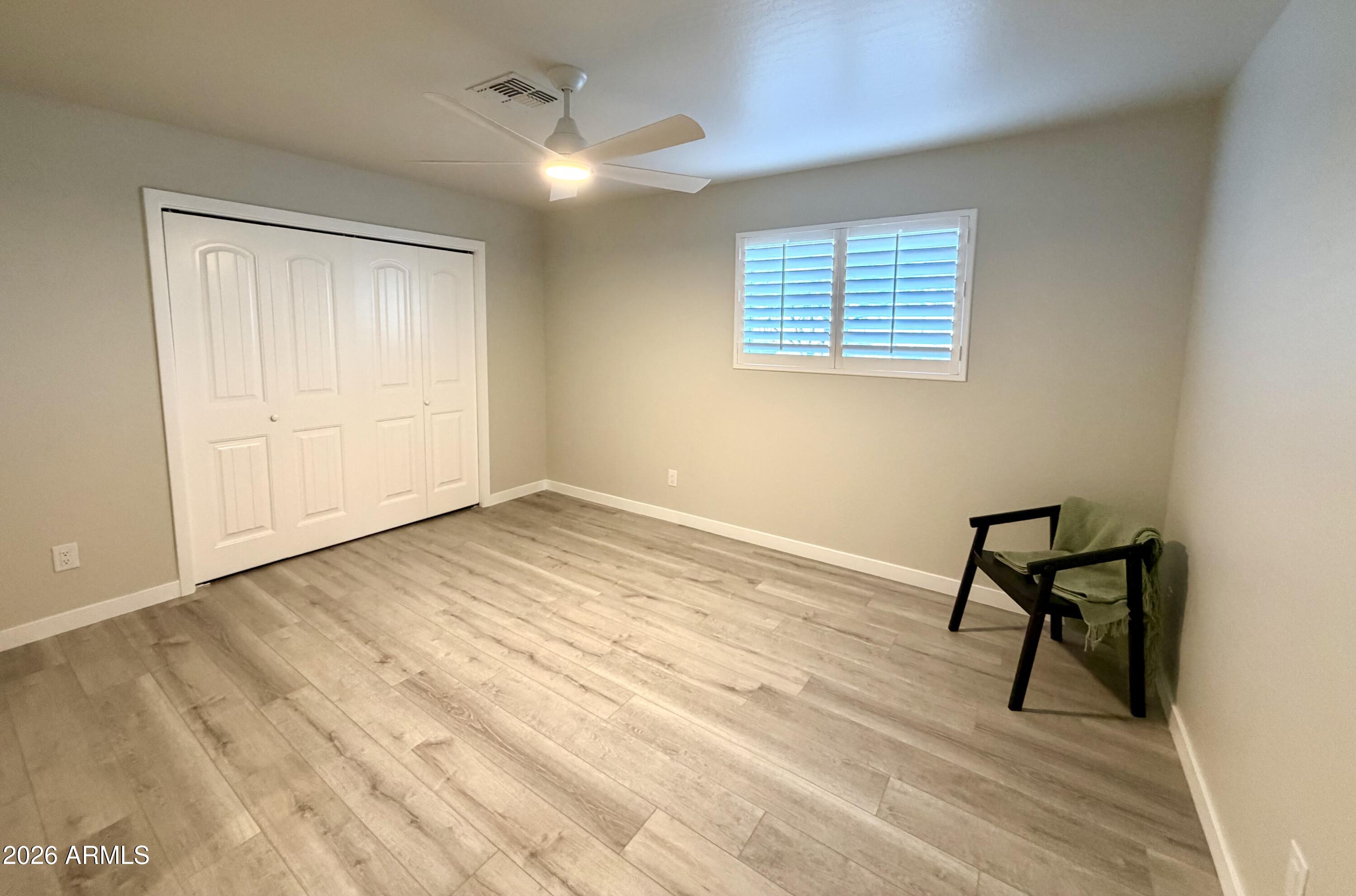 1165 North Mountain View Road Apache Junction, AZ 85119 - Photo 20 of 29 a view of an empty room with wooden floor and a window