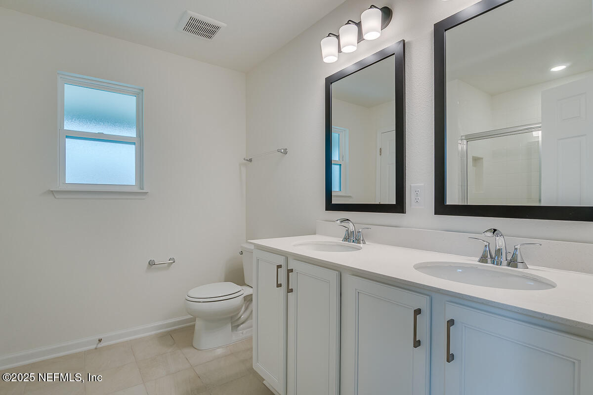 66 Stonecrest Drive St. Johns, FL 32259 - Photo 15 of 22 a bathroom with a toilet a sink a mirror and vanity
