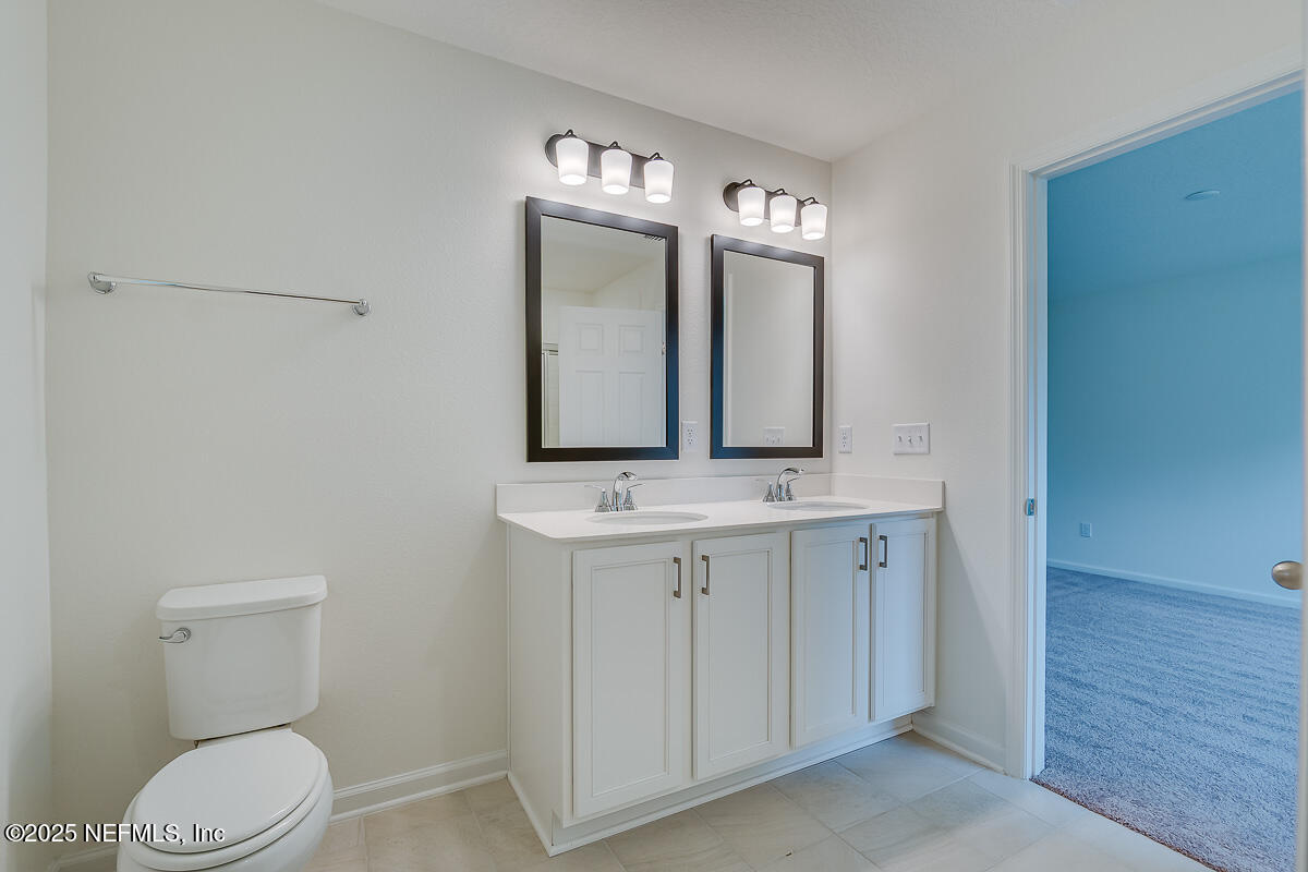 66 Stonecrest Drive St. Johns, FL 32259 - Photo 16 of 22 a bathroom with a toilet a sink and mirror