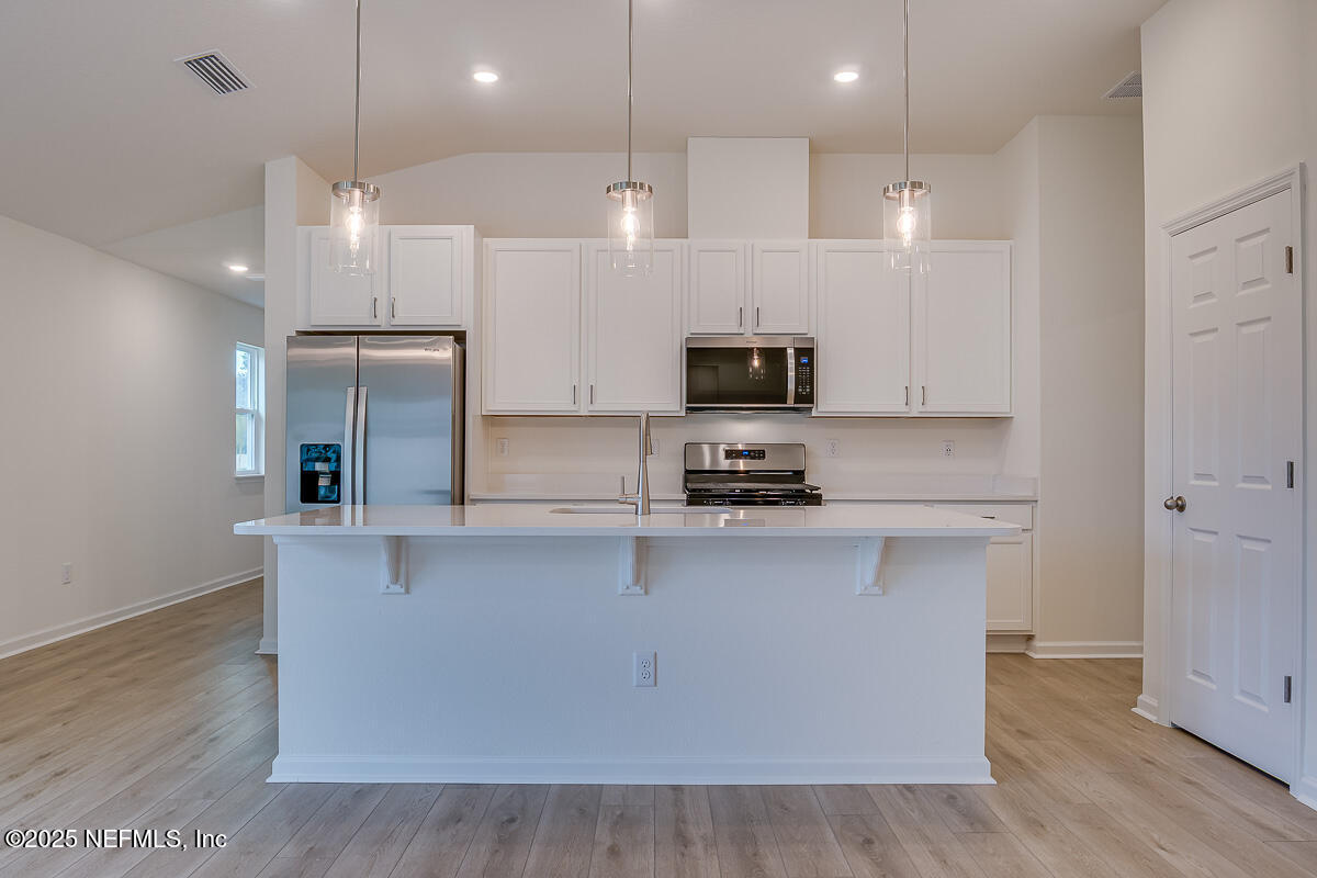 66 Stonecrest Drive St. Johns, FL 32259 - Photo 8 of 22 a large kitchen with stainless steel appliances a large counter top space cabinets and wooden floor