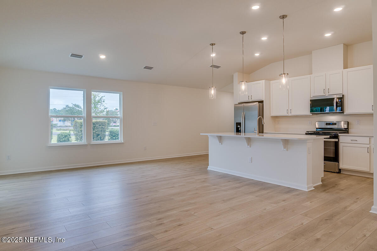 66 Stonecrest Drive St. Johns, FL 32259 - Photo 9 of 22 a view of kitchen with kitchen island stainless steel appliances a sink wooden floor and a window