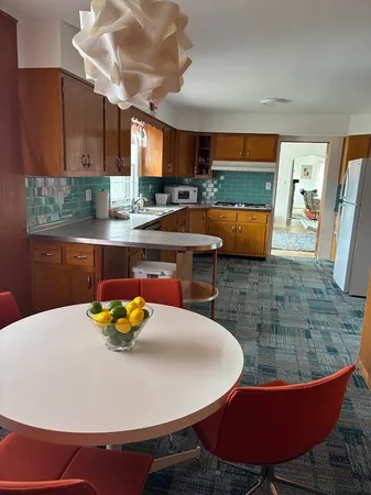 a kitchen with a table chairs and wooden floor