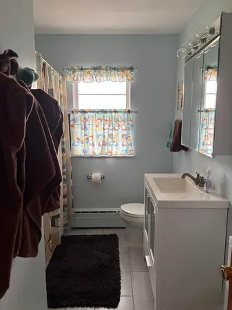 a bathroom with a sink toilet and window