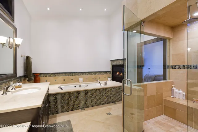 a bathroom with a tub sink and mirror