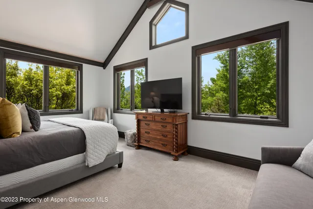 a bedroom with bed and flat screen tv