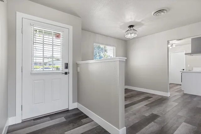 an entryway view with wooden floor and windows