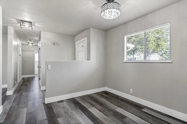 a view of empty room with wooden floor