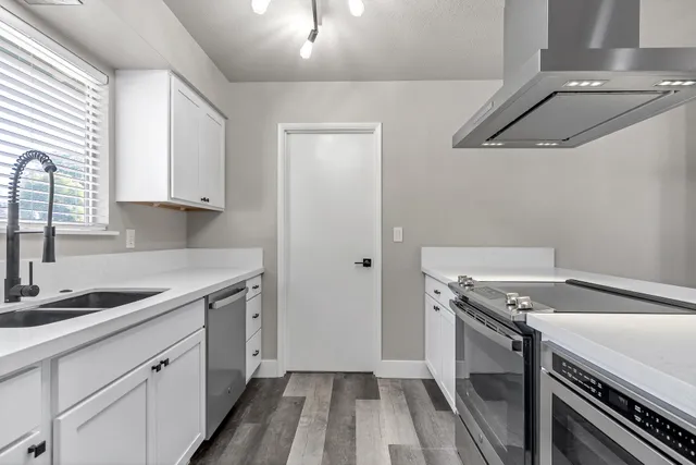 a kitchen with a sink and wooden floor