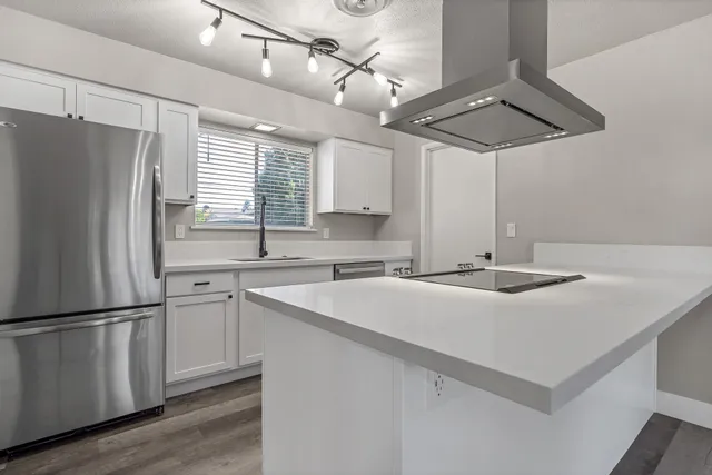 a kitchen with stainless steel appliances a sink and a refrigerator