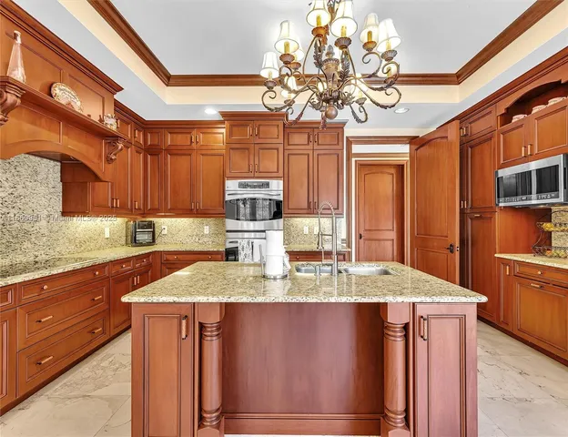 a living room with furniture a chandelier and a flat screen tv