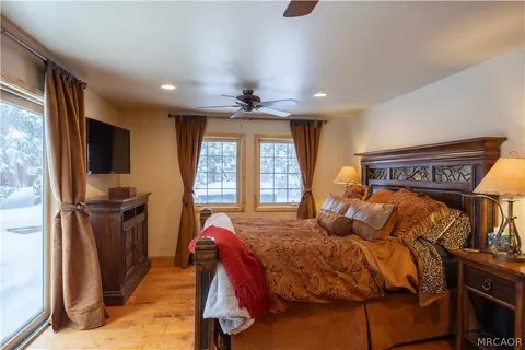 a bedroom with a bed and a flat tv screen on dresser