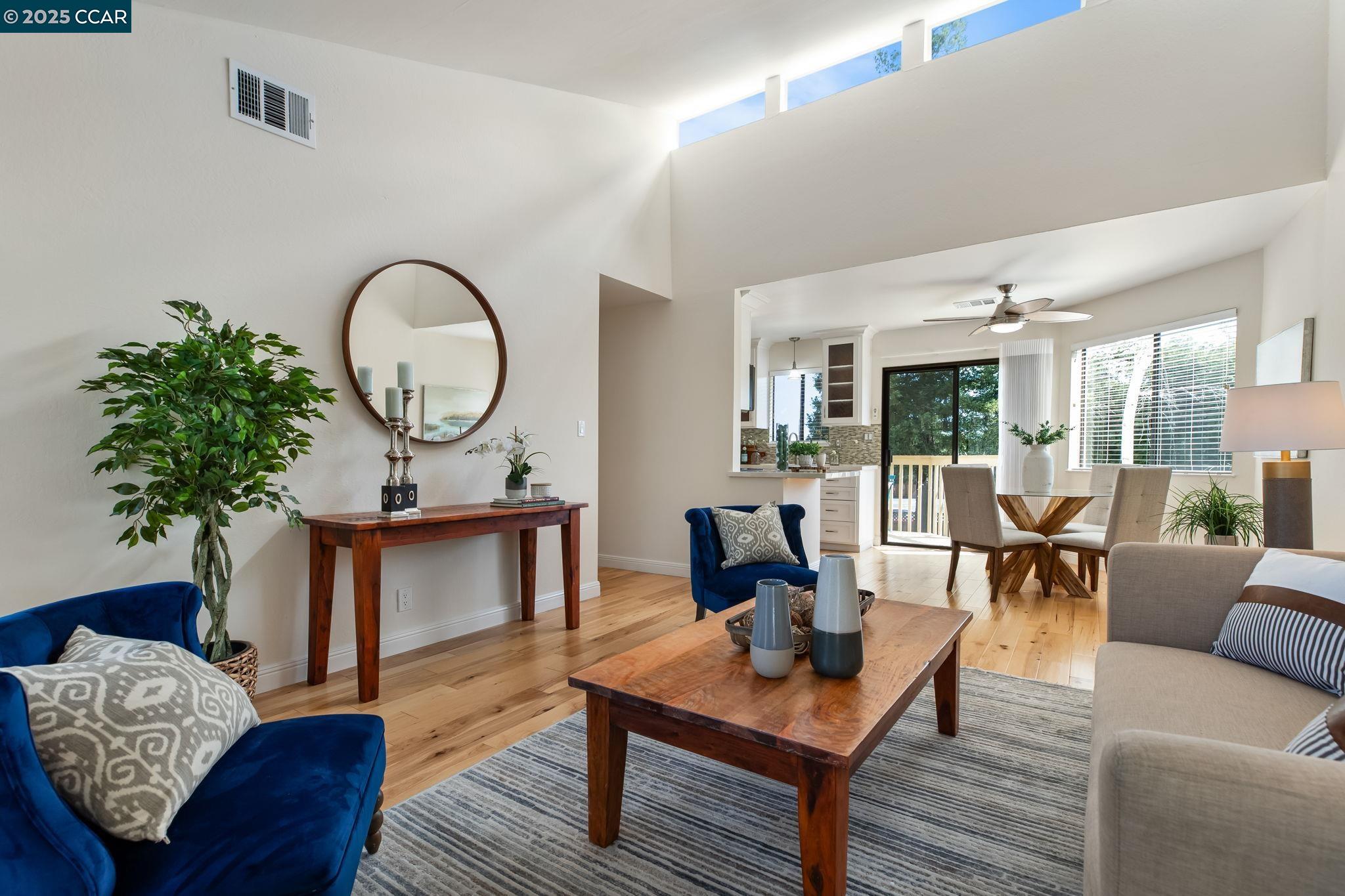 1945 Trinity Avenue, Unit 8 Walnut Creek, CA 94596 - Photo 1 of 45 a living room with furniture a rug and a floor to ceiling window
