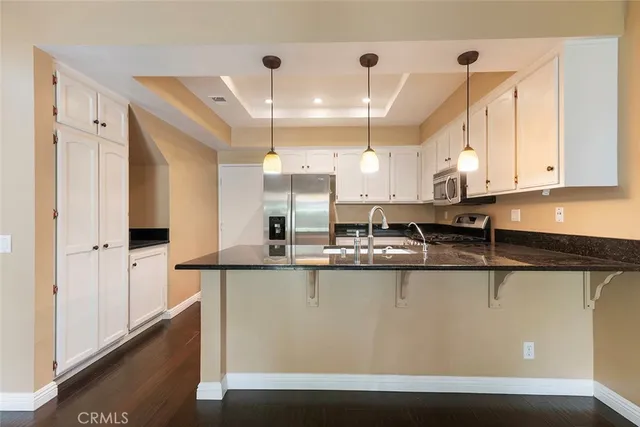 a kitchen with stainless steel appliances granite countertop a sink a stove and a refrigerator