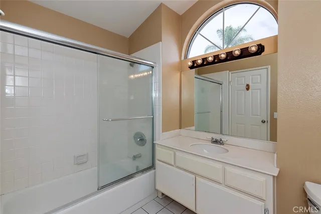 a bathroom with a granite countertop sink a mirror and a bathtub