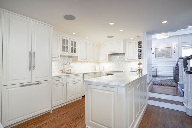 a kitchen with granite countertop white cabinets and white appliances