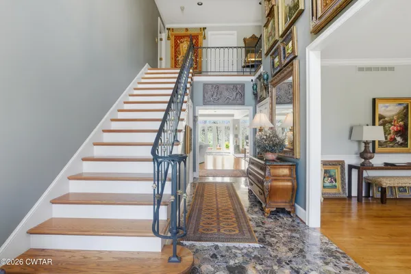 a view of entryway and hall with wooden floor