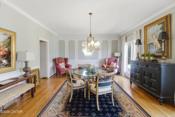 a dining room with furniture a rug and a chandelier