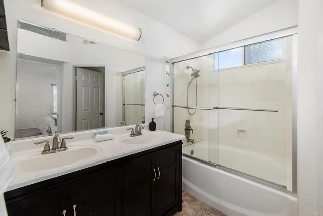 a bathroom with a shower sink vanity and mirror