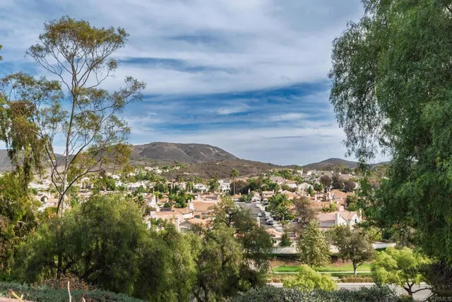 a kitchen with stainless steel appliances granite countertop wooden cabinets a sink dishwasher a stove and a refrigerator with wooden floor