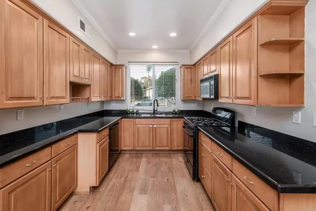 a open kitchen with stainless steel appliances granite countertop a refrigerator a sink and a stove