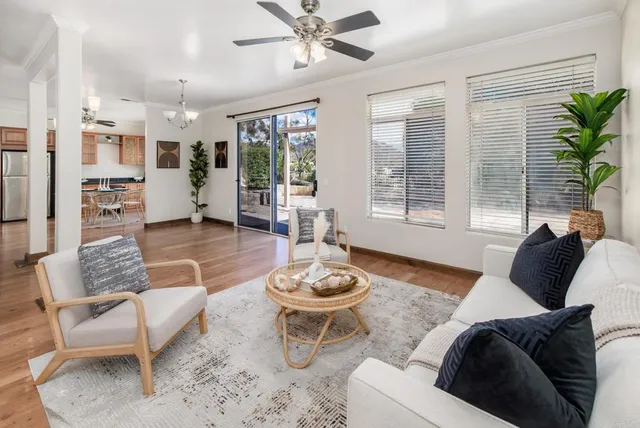 a dining room with furniture a floor to ceiling window and wooden floor