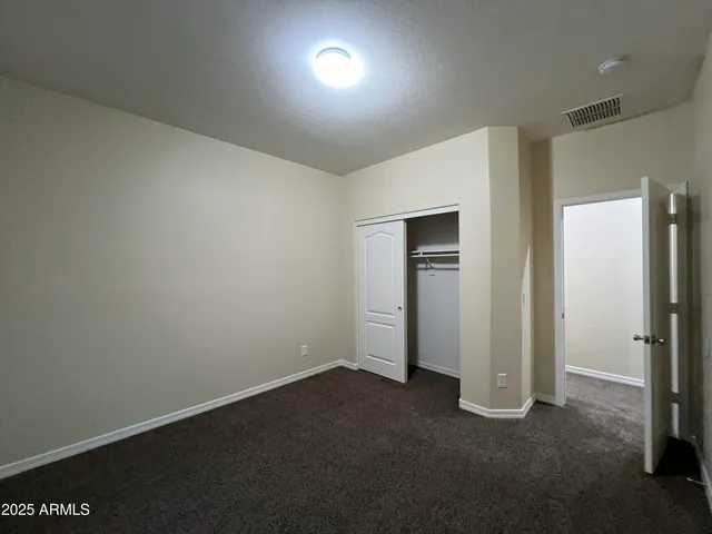 an empty room with closet and a window