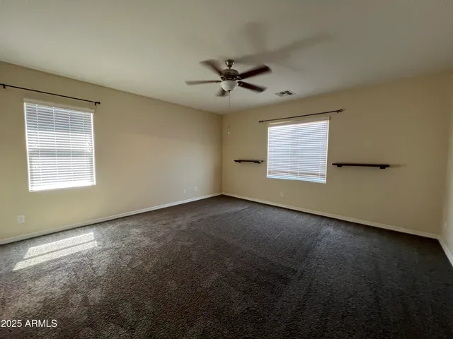 an empty room with a window and a ceiling fan