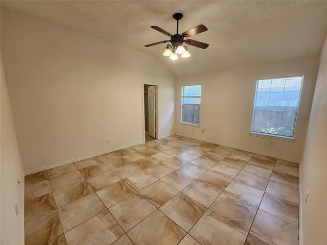 a view of a livingroom with a chandelier fan and windows