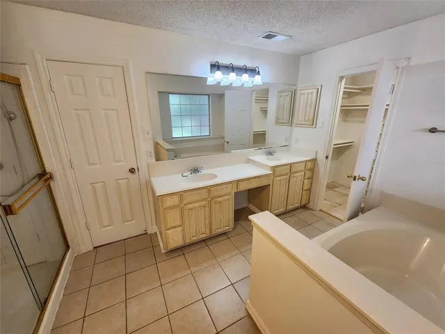 a view of a kitchen with a sink and dishwasher a refrigerator with white cabinets