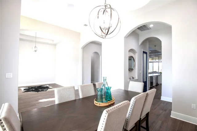 a living room with furniture a chandelier and a large mirror