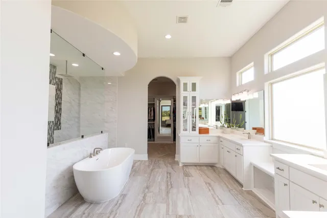 a bathroom with a sink a large mirror and a bathtub
