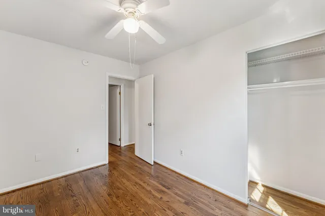 a view of a room with wooden floor and fan