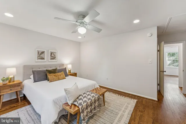 an empty room with wooden floor chandelier fan and windows