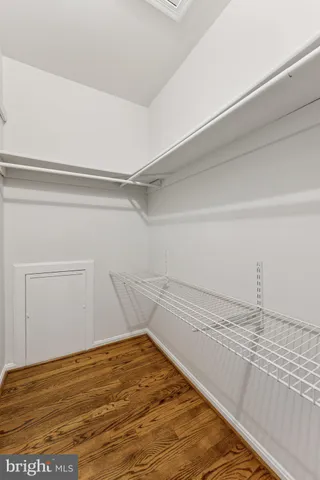 an empty room with wooden floor chandelier fan and closet area