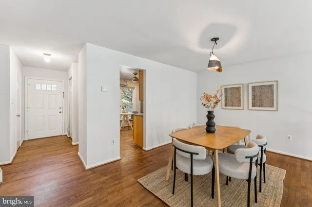 a kitchen with stainless steel appliances granite countertop a refrigerator a sink and white cabinets with wooden floor