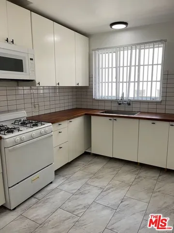 a kitchen with stainless steel appliances granite countertop a sink and a stove