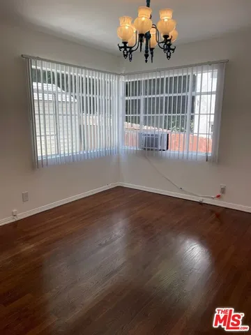 a view of wooden floor and a chandelier in living room