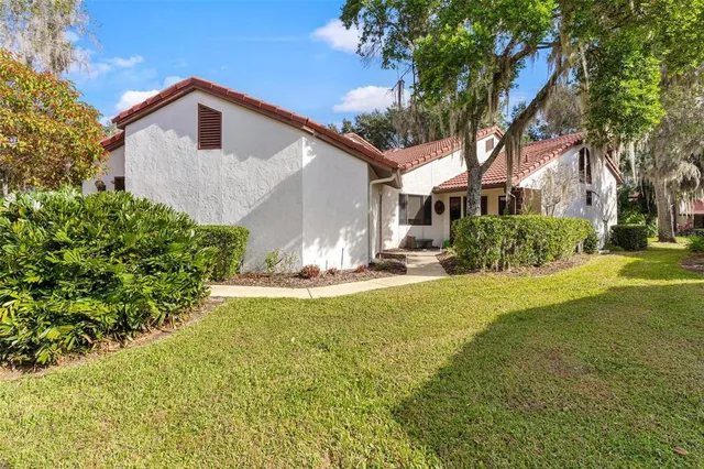 a front view of house with yard and trees around