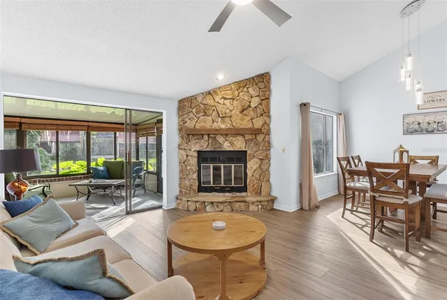 a living room with furniture a fireplace and a floor to ceiling window