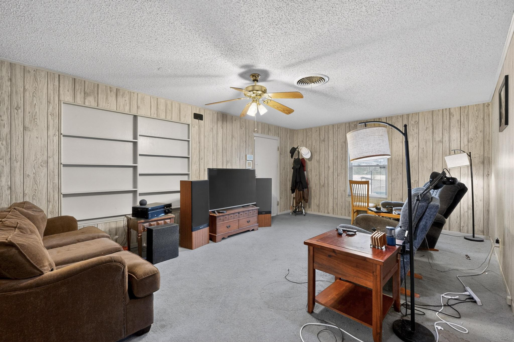 6808 Daugherty Street Austin, TX 78757 - Photo 11 of 20 a living room with furniture a flat screen tv and gym equipment
