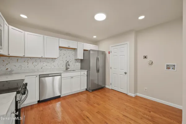 a kitchen with stainless steel appliances granite countertop a refrigerator and a stove top oven