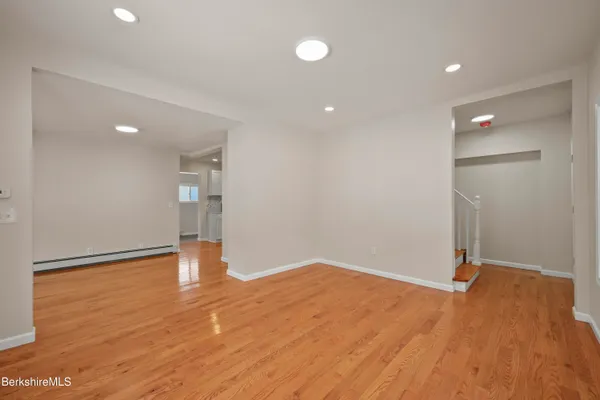 a view of empty room with wooden floor